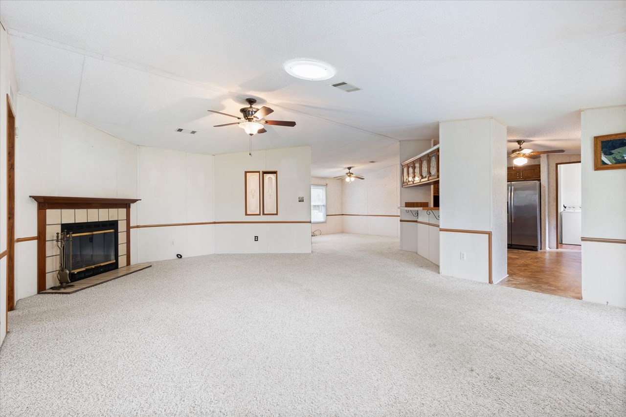 living room large living area is open to dining room and kitchen. there is a wood burning fireplace and sliding doors to the screen porch at the back of the house.
